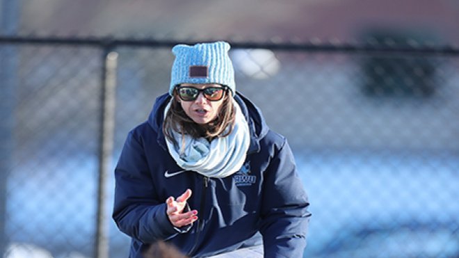 image of Jen Fox, Head Women's Lacrosse Coach, talking strategy with her team