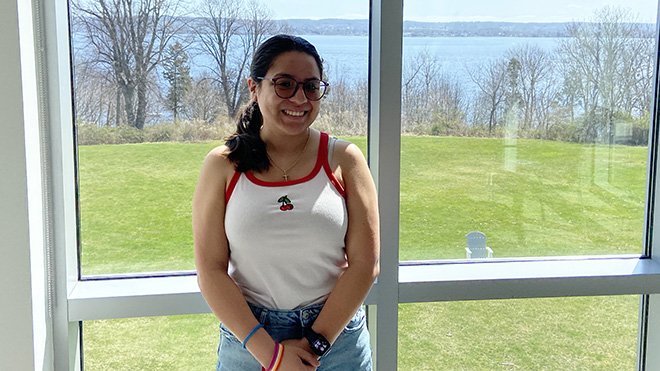 Senior Lucero Blanco stands in front of a window in GHH that looks out to the water