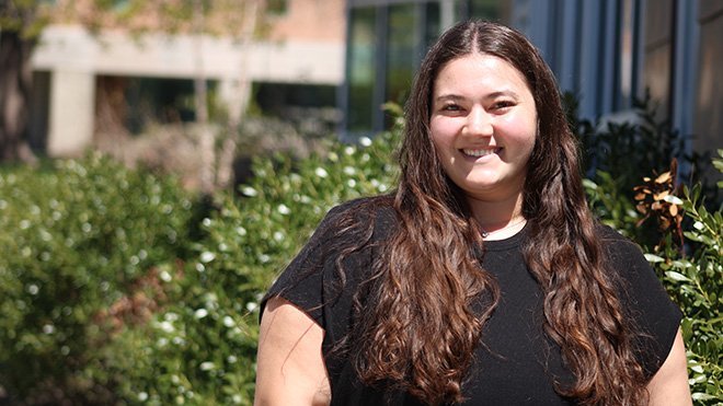 Senior Christina Marra wears a black t-shirt and stands outside