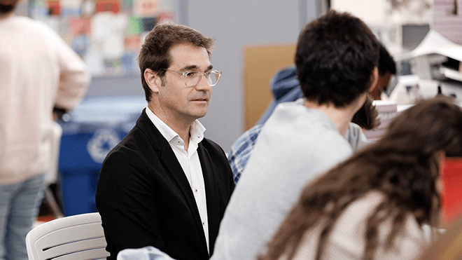 A photo of Rubén Alcolea reviewing work with a student