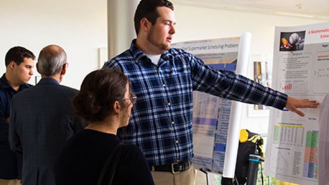 Student discusses his research at the Student Academic Showcase and Honors.
