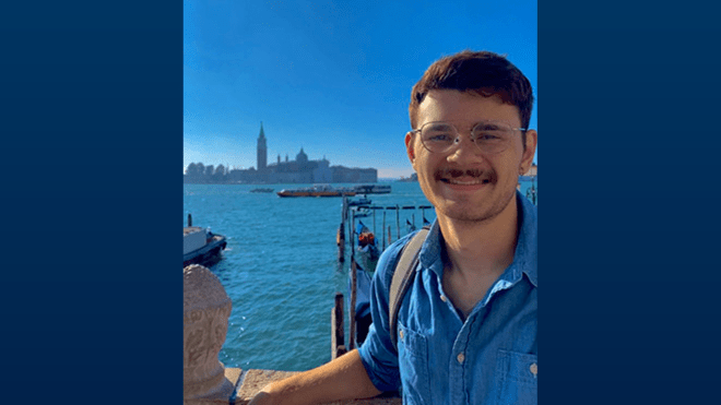 A photo of Sam Trieber by the water in Italy during a study abroad trip