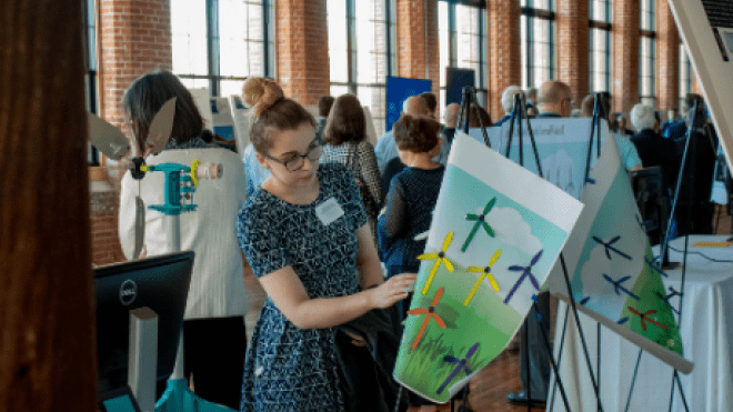 Student arranges poster. 