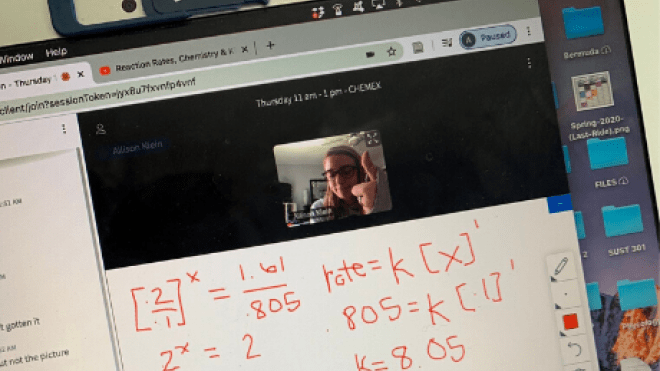 Photo of laptop showing equations written on a virtual whiteboard and student giving a thumbs up.