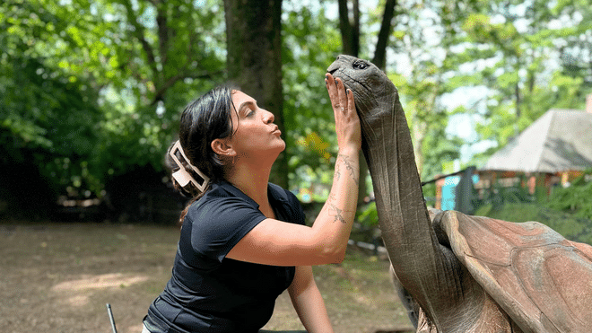 Victoria “Tori” Stephenson ’18 gently pets the neck of a large turtle.