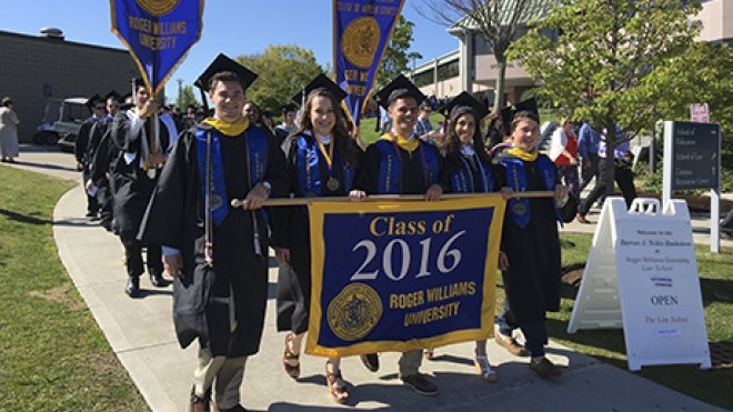 The Class of 2016 processes to commencement holding the class banner.