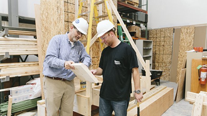 A student and professor work inside a construction lab.