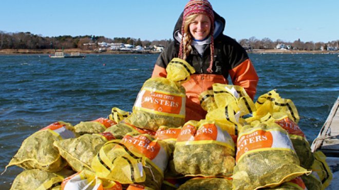 Oyster farmer with bags of oysters