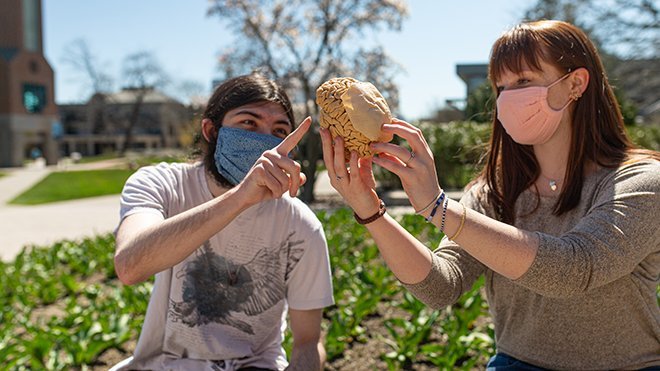 image of Josh Abston and Mackenzie Seccombe holding RWU's plasticized brain outside on our beautiful Bristol campus
