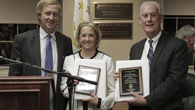 Two men and a woman pose with awards.