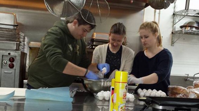Students prepare meals in a soup kitchen.