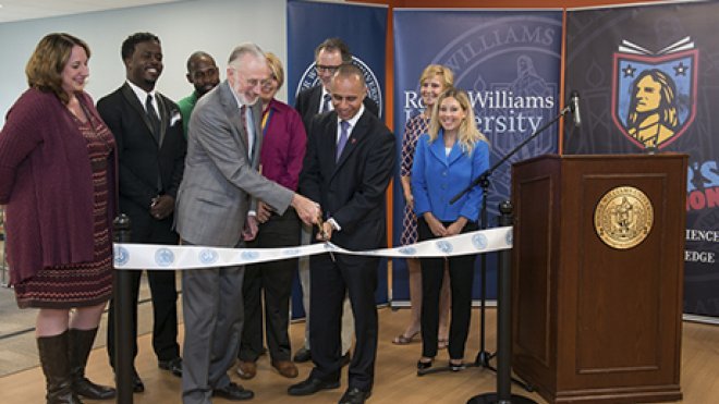 University administrators gather with state and city officials to cut the ribbon on a new campus building.