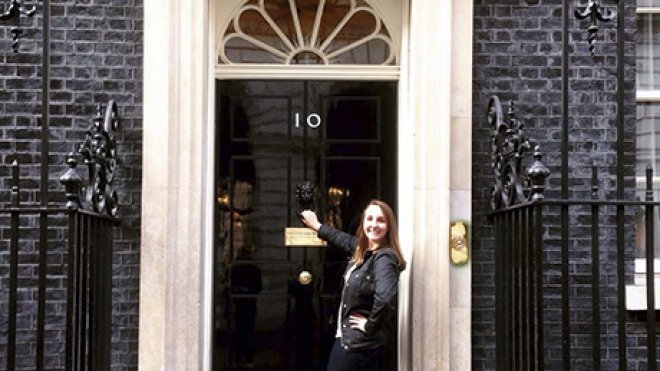 A student stands in front of the headquarters of the British government.