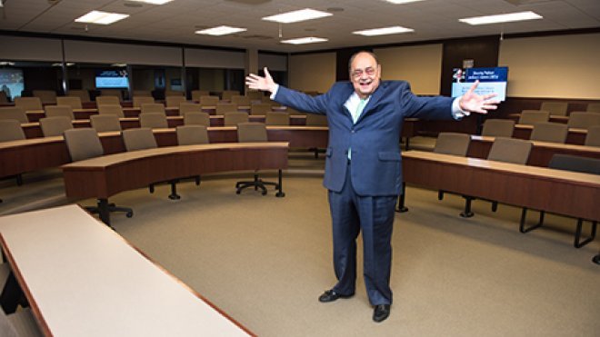 Professor Santoro stands inside the classroom dedicated to him.