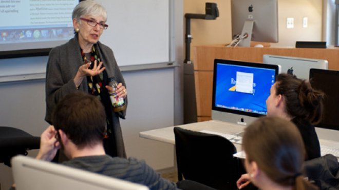 Visiting scholar speaks to students in a classroom.