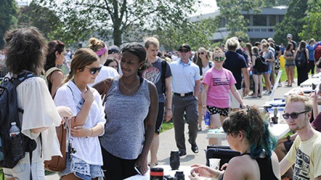 Students talk to fellow students about getting involved in clubs and organizations.