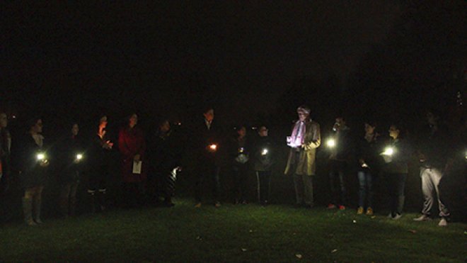 Students, faculty and staff gather to hold a candlelight vigil on campus.