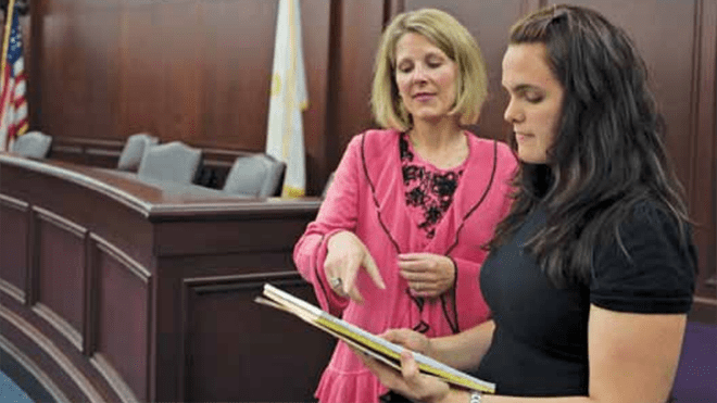 Tricia Martland assists a student in the courtroom 