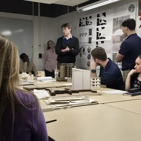 Students presenting their research gathered around a table
