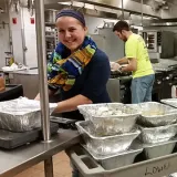 A headshot Kelsey Rogers working in the RWU kitchen