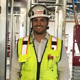 Jared Ramos wears a hard hat and vest