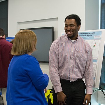 A student speaking with a faculty member.