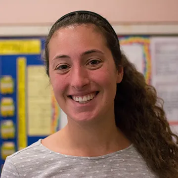 A headshot of Meghan Curran in a middle school classroom