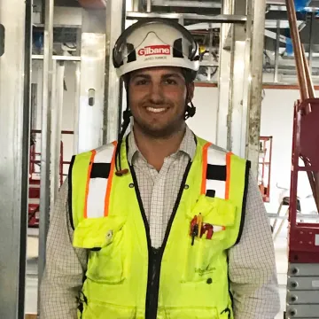 Jared Ramos wears a hard hat and vest 