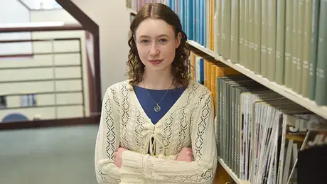 Sarah Baker stands in the Architecture Library at RWU.
