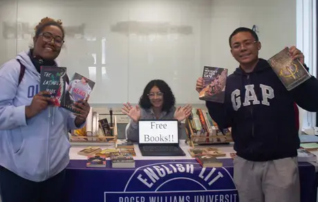 Students holding up books at Book Nook