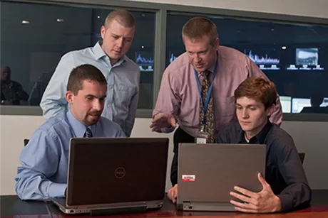 Four people looking at computers.