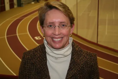 Athletic director stands on indoor track.