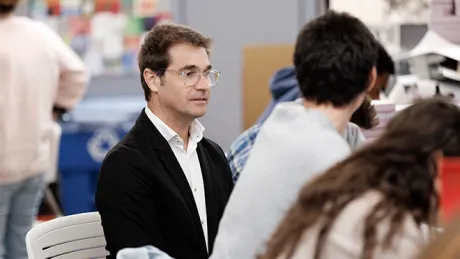 A photo of Rubén Alcolea reviewing work with a student