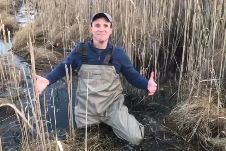 Person crouching in mud.