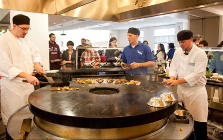 Chefs prepare food in dining hall