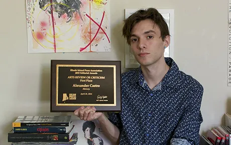 An alumnus holds his journalism award.
