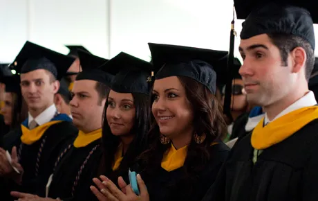 Students watch graduation ceremony.