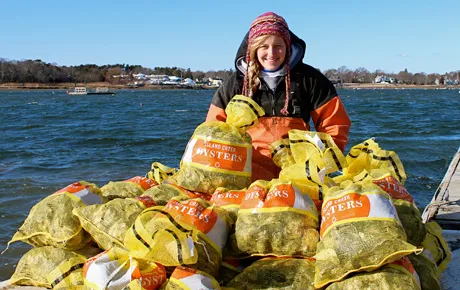 Oyster farmer with bags of oysters