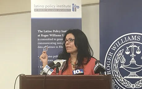 A woman addresses an audience at a press conference.