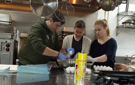 Students prepare meals in a soup kitchen.