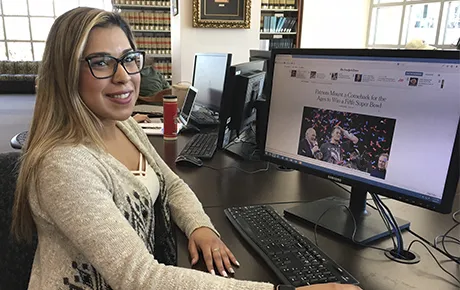 A student reads the New York Times website inside the library.