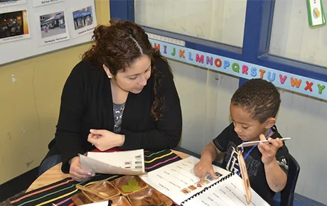 A teacher goes over a lesson with an elementary school student.