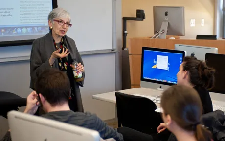 Visiting scholar speaks to students in a classroom.