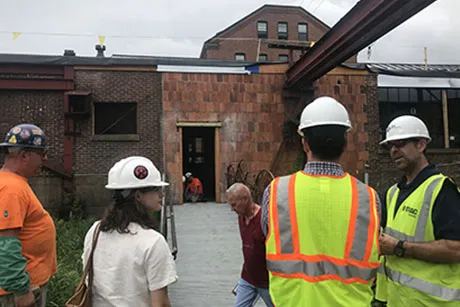 People in hard hats work on the Super Studio