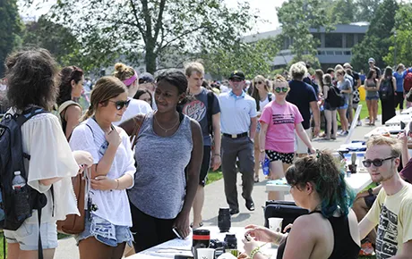 Students talk to fellow students about getting involved in clubs and organizations.