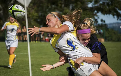 RWU rugby player passes to a teammate before she gets tackled by the opposing team.