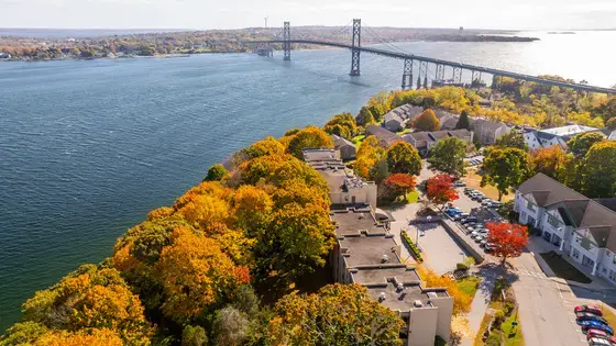 Aerial view of Roger Williams University’s Bristol campus on Narragansett Bay, with the Mount Hope Bridge visible