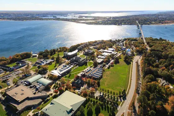 Aerial view of Roger Williams University’s Bristol campus on Narragansett Bay, with the Mount Hope Bridge visible