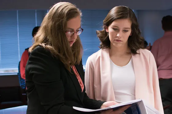 Two students review a report.