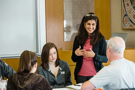 Communications professor working with students.